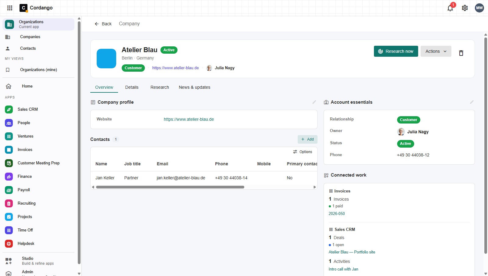 An organization record for Atelier Blau, showing a Connected work panel where Invoices and Sales CRM each contribute to the same company: one paid invoice, one open deal and a logged intro call.